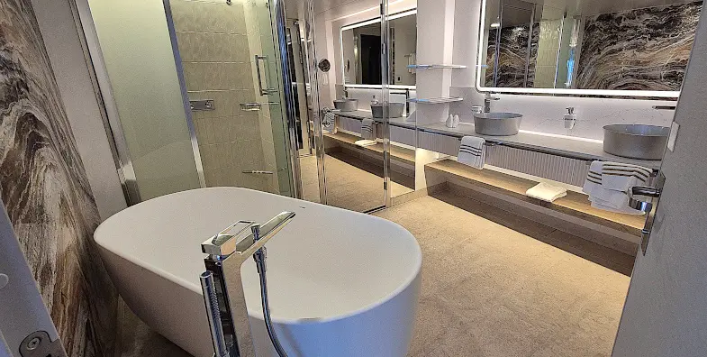 De badkamer-en-suite van de Große Freiheit-suite op de Mein Schiff Relax heeft een ligbad, een apart toilet, een infrarood-sauna, een douche en een vrijstaand bad. © Nico van Dijk / Decruisegids.nl