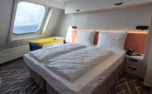 In de ouderslaapkamer en de woonkamer van de familiehut zitten grote ramen waardoor je over de boeg van de Mein Schiff Relax kunt kijken. © Nico van Dijk / Decruisegids.nl