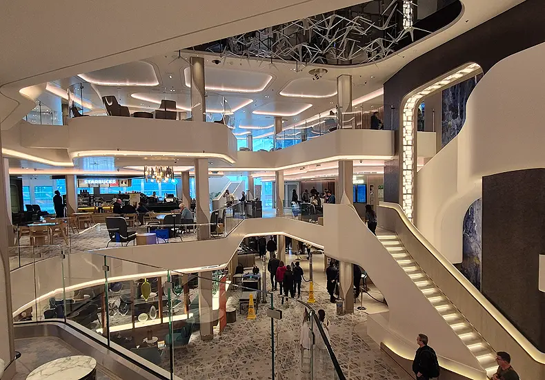 In het drie dekken tellende atrium van de Norwegian Prima domineren organische vormen en terra-kleuren. Er is ook een Starbucks aan boord.. © Nico van Dijk / Decruisegids.nl
